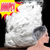 A pile of white disposable shower caps with elastic edges is shown next to a model's head.