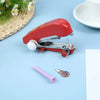 A red portable handheld sewing machine is shown on a light blue surface next to a pink needle and thread.