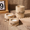 Three rustic wooden tea light holders with natural twine tied around the base resting on a wooden surface.