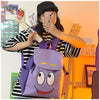 Eine Person hält einen lila Dora The Explorer Flanell-Rucksack und macht ein Foto.