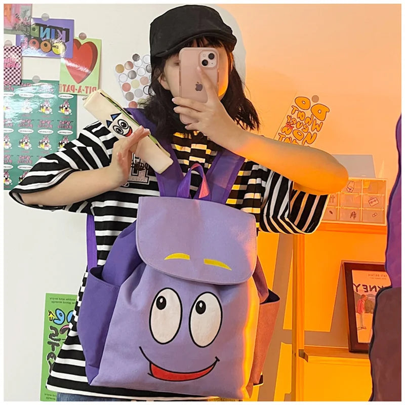 Eine Person hält einen lila Dora The Explorer Flanell-Rucksack und macht ein Foto.