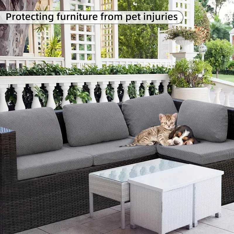 Graue L-förmige Outdoor-Sofa mit hellem Glastisch und einer Katze auf den Kissen.