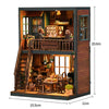 A wooden dollhouse miniature assembly kit featuring a detailed interior with stairs and furniture.