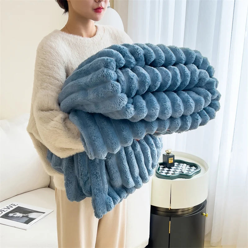 A fluffy blue fleece blanket is draped over a person's arm in a bright indoor setting.