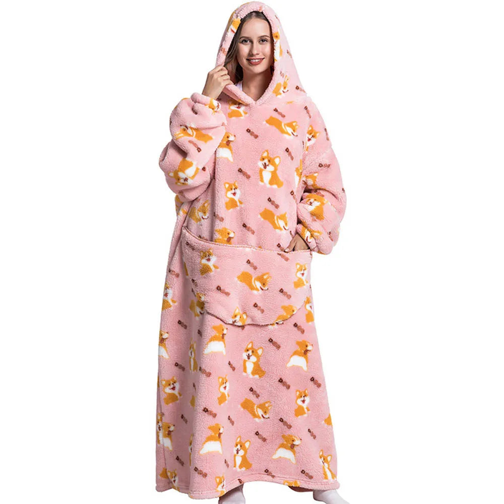 A woman wearing a pink animal print oversized wearable blanket hoodie with a hood and pockets.