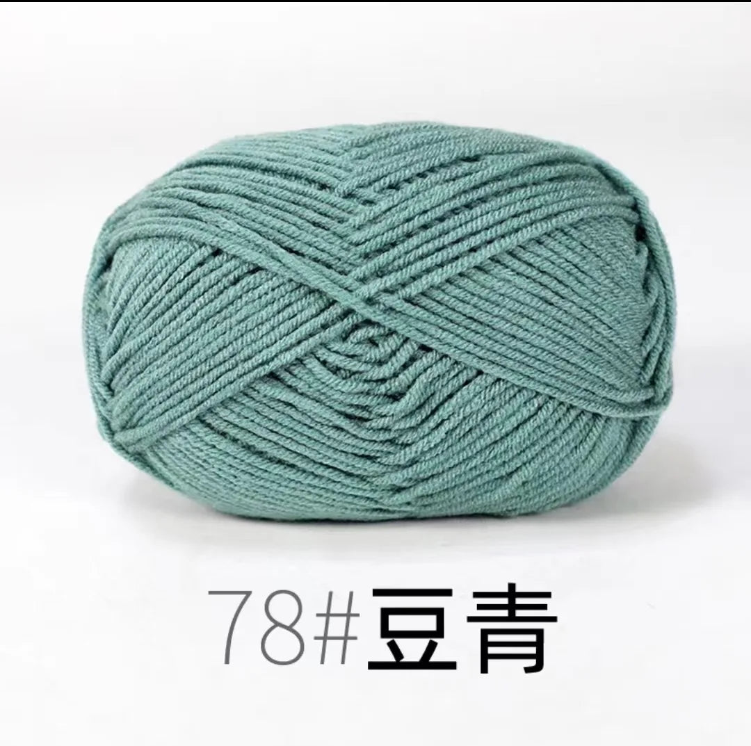 A ball of teal colored 4-ply milk cotton yarn for knitting and crochet.
