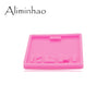 A pink silicone resin mold with a rectangular shape and molded features for making badge backings or keychains.