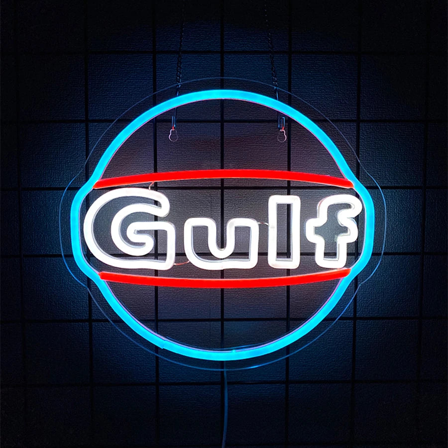 A glowing neon sign shaped like a Gulf symbol with the word Gulf in white and red light against a dark background.