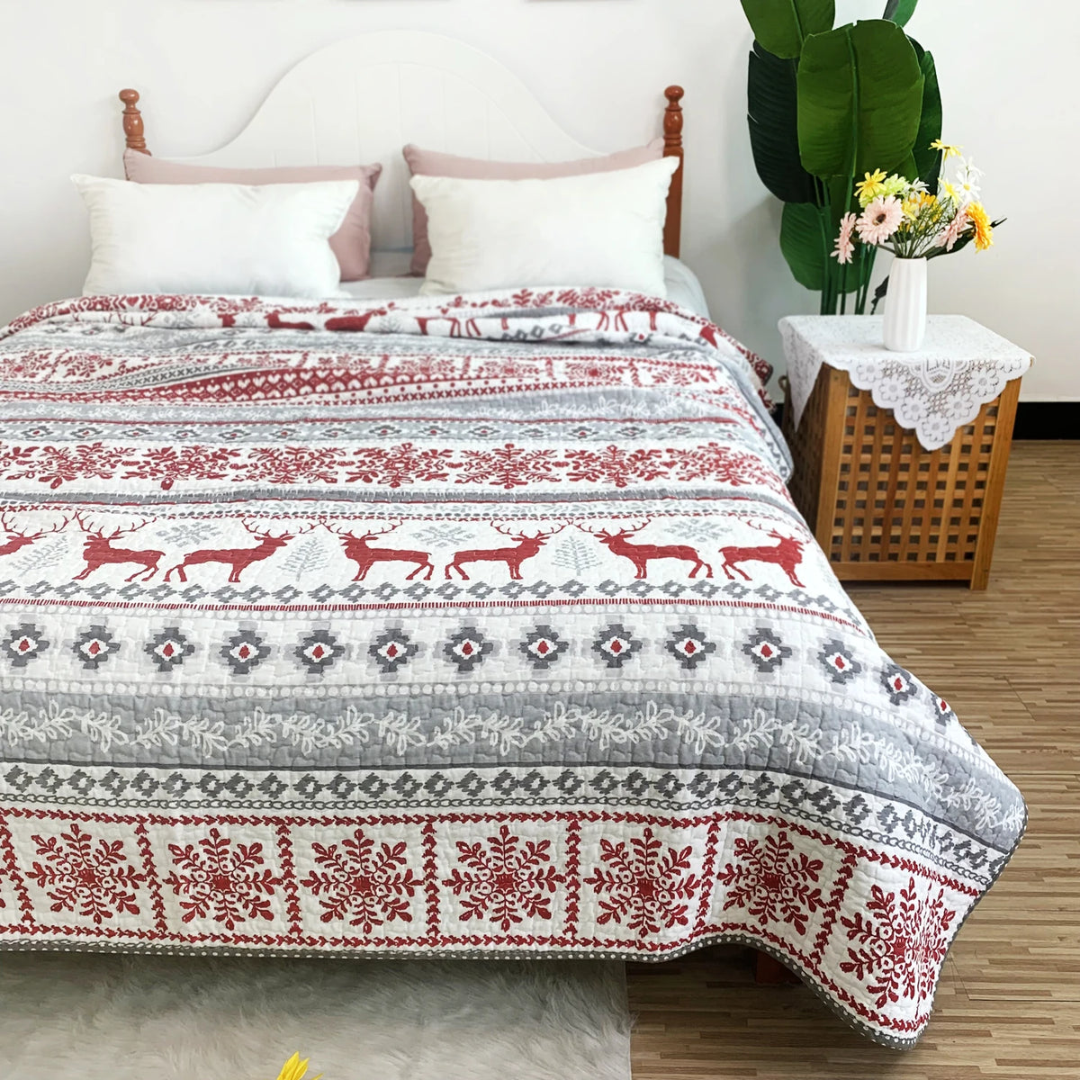 A red and white patterned patchwork cotton bedspread displayed on a bed with white pillows.