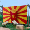 Grande bannière décorative avec le logo McDonald's en arc doré sur fond rouge avec motifs de soleil jaune.