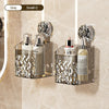 A glass wall-mounted suction cup storage basket with a water ripple design holding perfume bottles and a small glass jar.