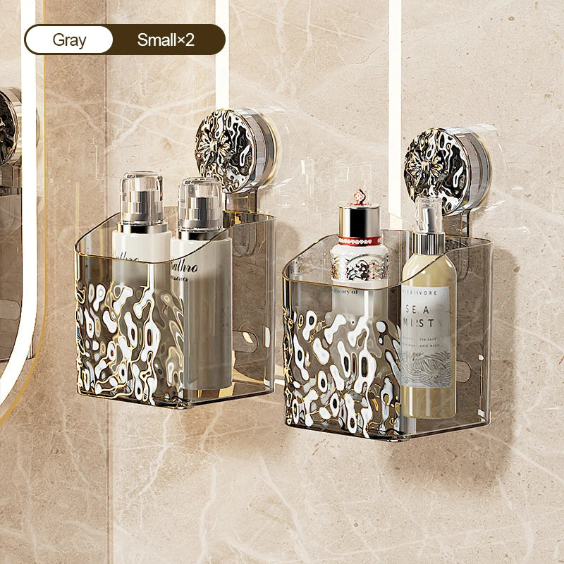 A glass wall-mounted suction cup storage basket with a water ripple design holding perfume bottles and a small glass jar.