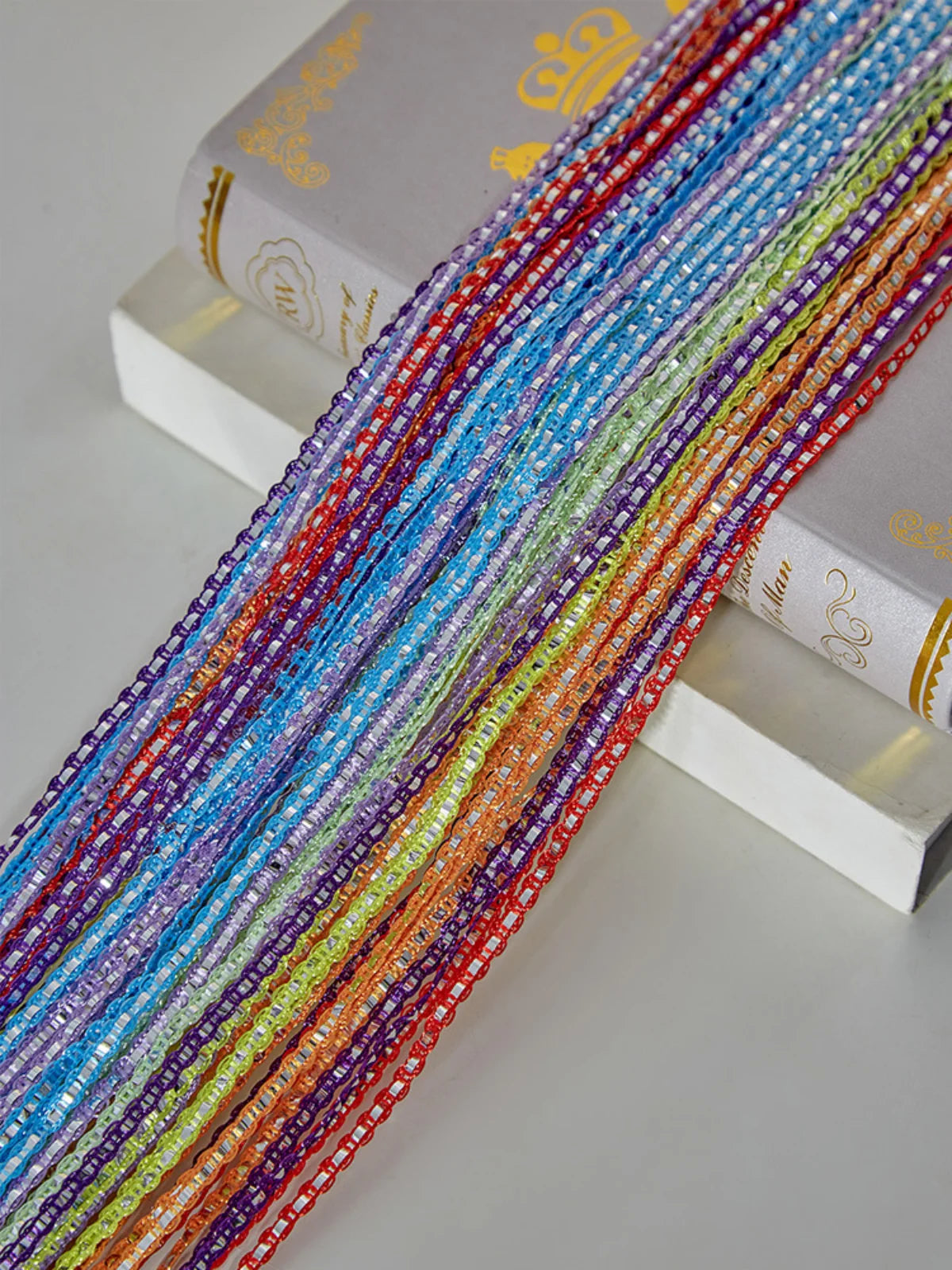 A close-up of colorful boho tassel string curtain cords in various shades of blue, pink, orange, and purple.