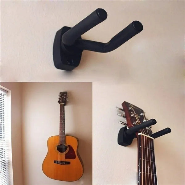 A black wall-mounted guitar hanger with screws is shown on a white wall.