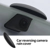 A black car reversing camera rain cover is shown mounted on a vehicle body.