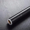 Roll of black self-adhesive wood grain cabinet and furniture refacing film