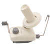 A compact hand-operated yarn ball winder with a white cylindrical spindle and a light beige base.