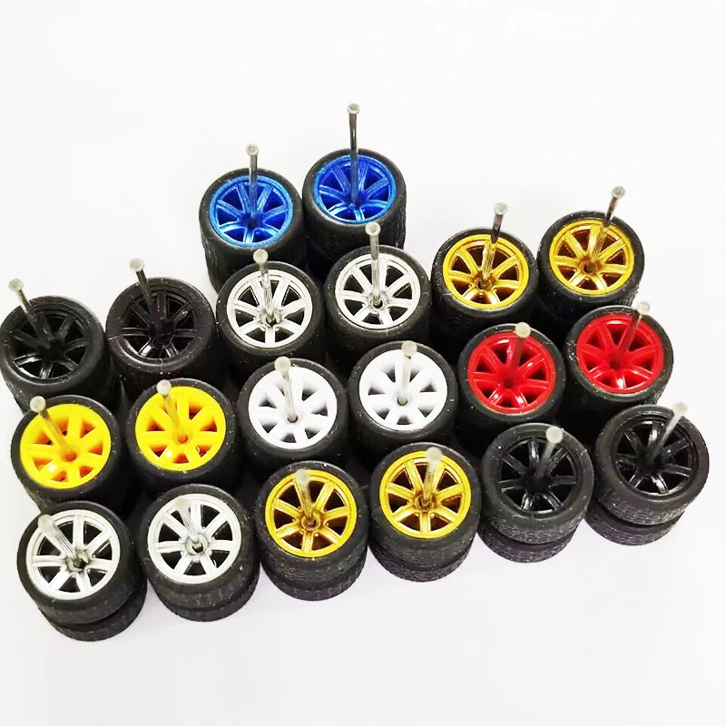 A collection of ten pairs of 1:64 scale alloy car wheels and tires in various colors including blue, yellow, and black.