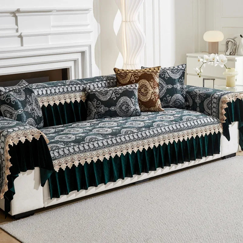 A dark teal and gold patterned sofa cover with quilted protection displayed on a white sofa.