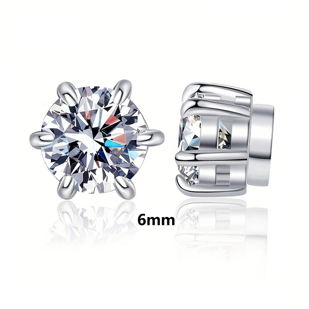 A pair of silver magnetic zircon stud earrings shown next to a measurement scale.