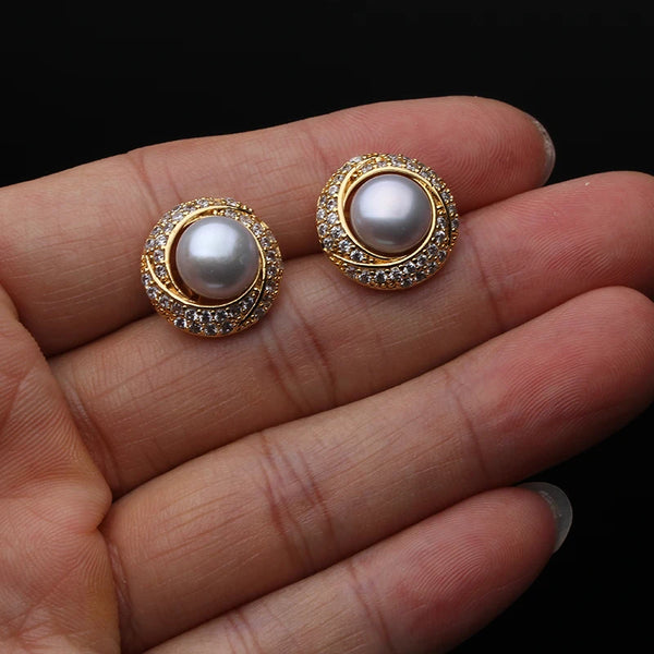 Une paire de boucles d'oreilles à pavé de perles d'eau douce naturelles posées sur la main d'une personne.