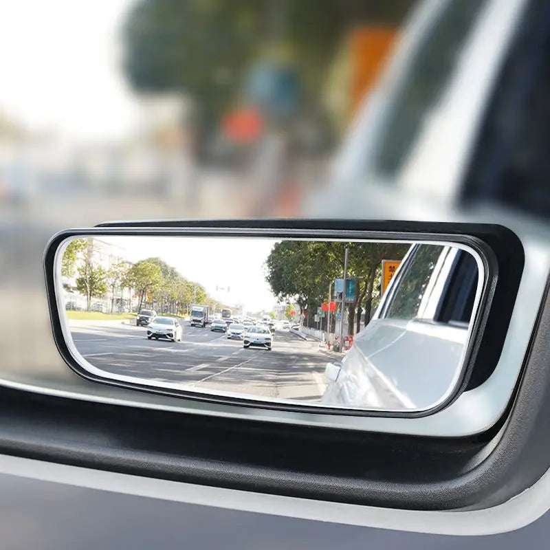 A close-up view of a car's side mirror showing a clear reflection of the road and surrounding traffic.