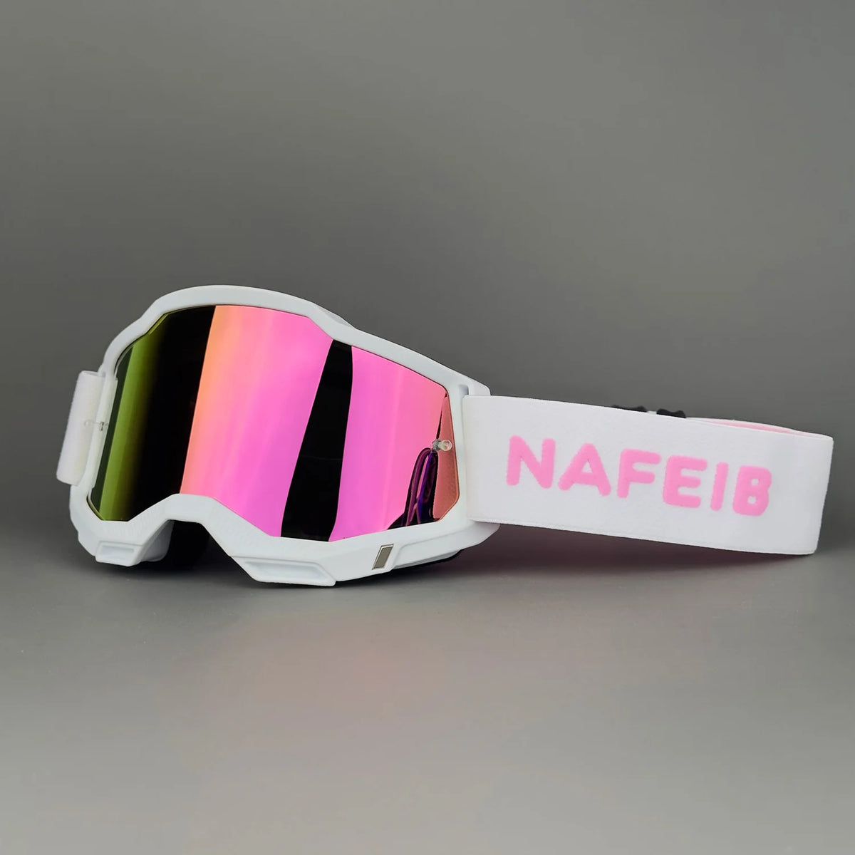 White professional MX off-road goggles with a vibrant iridescent lens and a pink strap labeled NAFE18