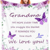 A woman smiles while holding a purple floral blanket with text that says We love you