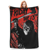 A woman holds up a black fleece throw blanket featuring a distressed graphic of Friday the 13th and the 13th.