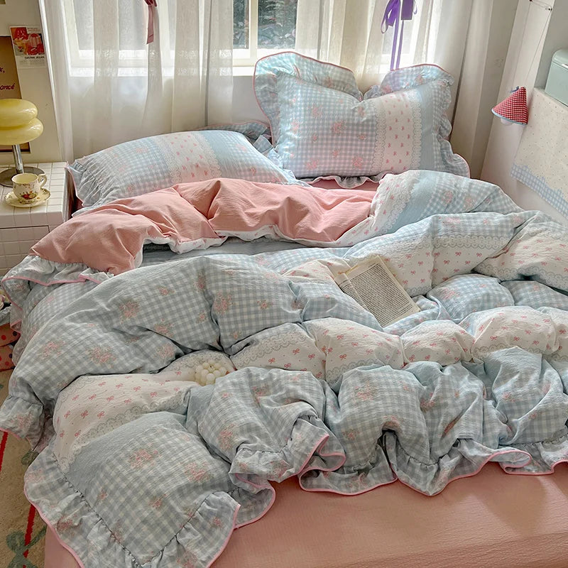 A floral duvet cover set featuring light blue and pink patterned fabric with matching pillowcases and a flat sheet displayed 