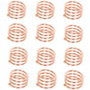 A set of twelve decorative metal napkin rings with a hollow-out pattern, finished in rose gold color.
