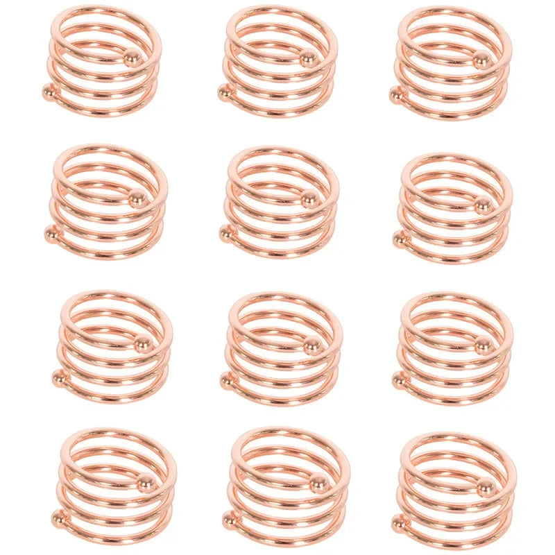 A set of twelve decorative metal napkin rings with a hollow-out pattern, finished in rose gold color.