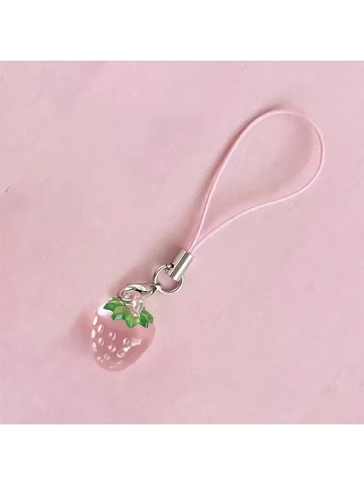 A pink strawberry resin charm attached to a silver keychain with a pink cord.