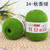 A ball of bright green yarn labeled as 34-Autumn scent yarn resting on a woven mat.