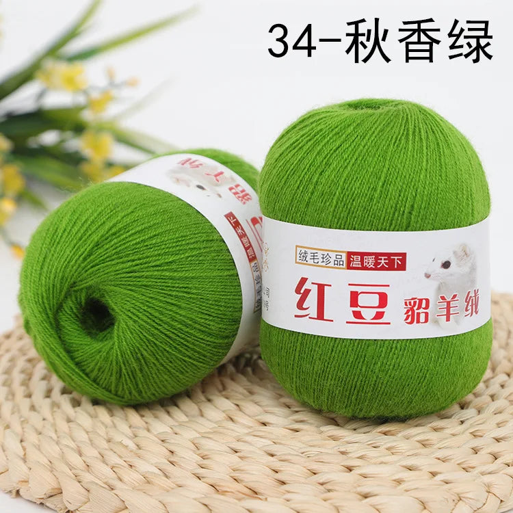 A ball of bright green yarn labeled as 34-Autumn scent yarn resting on a woven mat.