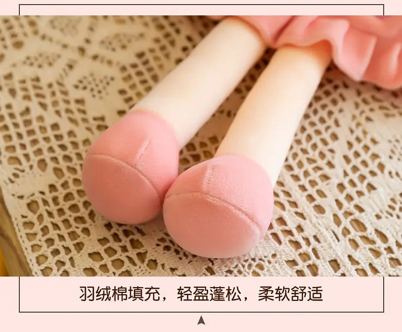 A close-up of a pink rabbit fairy plush doll with soft, rounded ears and body, resting on a lace-textured surface.