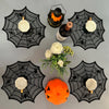A set of disposable spider web placemats featuring white bowls and an orange pumpkin decoration.