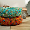 A vibrant orange and blue bohemian cotton linen floor cushion with a patterned fabric resting on a wooden surface.