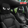 A pair of black car headrest covers with slanted eyes are shown inside a vehicle interior.