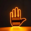 A glowing orange LED middle finger car light shaped like a hand, resting on a wooden surface.