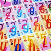 A close-up of a deck of Omega Card Game cards featuring colorful numbers and symbols.