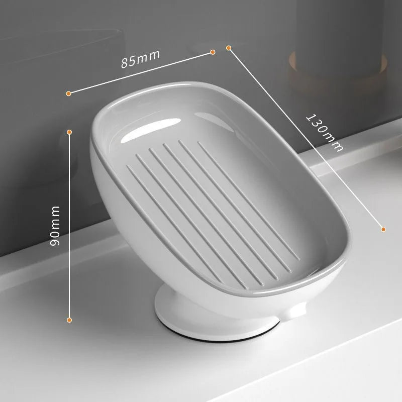 A white suction cup soap holder with a drainage tray shown in profile view.