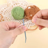 Hands are using bent tip tapestry needles to thread yarn for knitting or weaving.