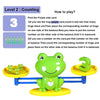 A green frog balance math game toy showing a purple side card and a number on the other side.