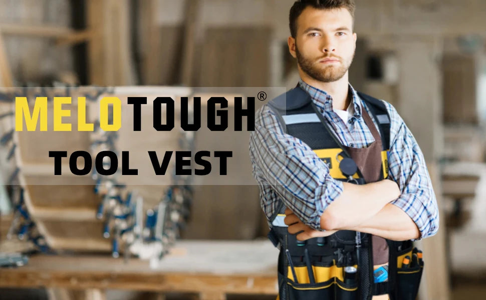 A man wearing a yellow and black tool vest in a workshop setting.