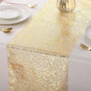 Metallic gold glitter table runner displayed on a white tablecloth with tableware.