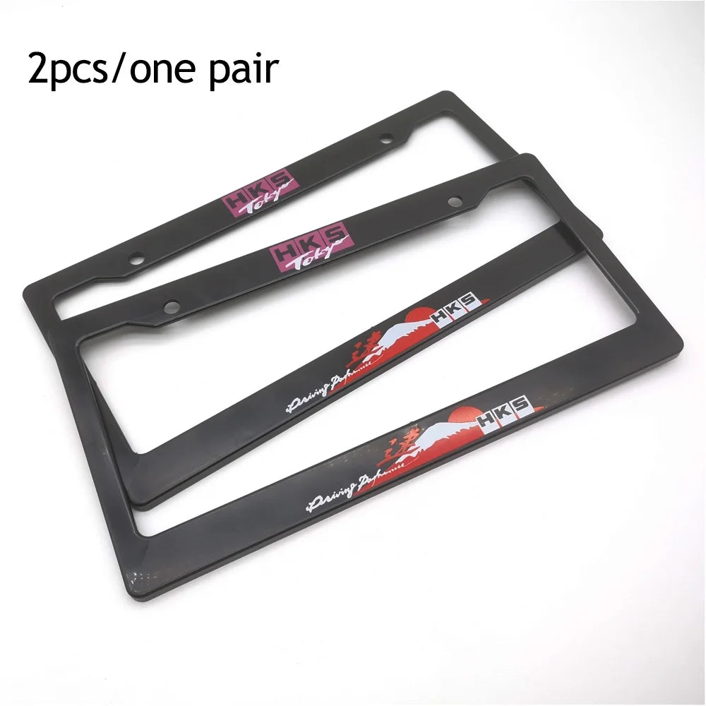 A pair of black racing style license plate frames with red and white decals for a JDM aesthetic.