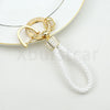 Gold and white pearl-encrusted TPU key fob cover with a white braided strap