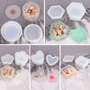 A collection of silicone jewelry boxes and resin molds in various shapes and colors, including hexagonal, round, and heart-sh
