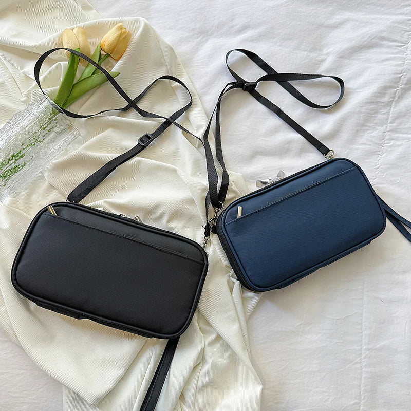 A navy blue waterproof passport and document organizer wallet with black strap lying on a white cloth.